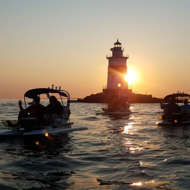 Two guests riding a mini powerboat across the water in daylight
